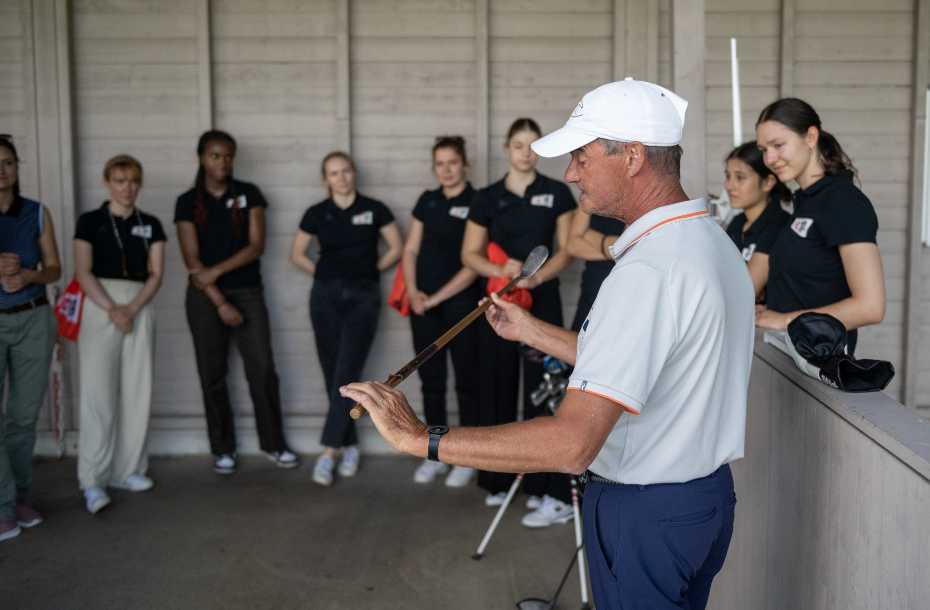 Die Akademie-Spielerinnen hören gespannt den Anweisungen des Golf-Profis zu